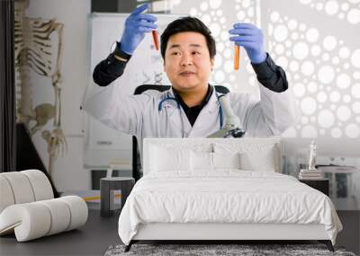 science, chemistry, biology, medicine and people concept - close up of young Asian Japanese male scientist holding two test tubes with red liquid making test or research in clinical laboratory Wall mural