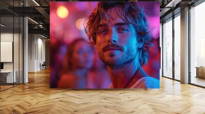 Young man in nightclub with vibrant lights around Wall mural