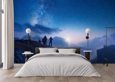 Group of travelers looking at the starry sky in the mountains Wall mural