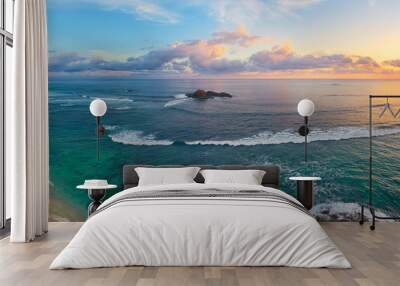 Panoramic view of tropical beach with surfers at sunset. Wall mural