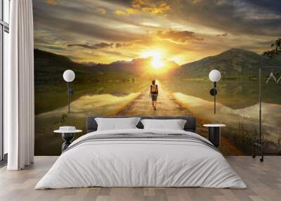 Traveler walking along the road to the mountains Wall mural