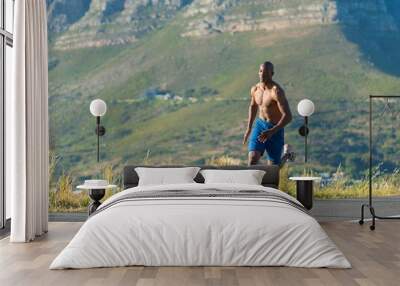 Athletic,  black male running along a road Wall mural