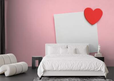 Blank paper note and red heart on pink paper background. Valentine's Day. Wall mural