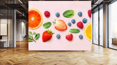 Fresh berry and fruit mix border frame banner of various ripe berries and mint leaves on pink background. Flat lay. Fruit pattern Wall mural