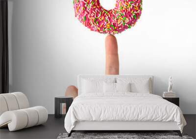 Pink doughnut is balanced on the index finger isolated on white. Concept image Wall mural