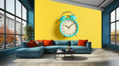 Turquoise vintage alarm clock on yellow background. Top view. Flat lay Wall mural