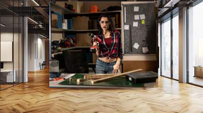 Woman with a drill screwdriver working in the workshop Studio alone Wall mural