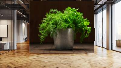 a bunch of green dill and parsley in an iron bucket, dark wooden background, concept of fresh vegetables and healthy food Wall mural