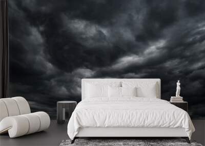 dark dramatic sky with black stormy clouds before rain or snow as abstract background, extreme weather, the sun shines through the clouds, high contrast photo Wall mural