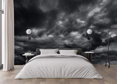 dark dramatic sky with black stormy clouds before rain or snow as abstract background, extreme weather, the sun shines through the clouds, high contrast photo Wall mural