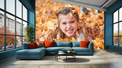 Happy child playing, posing, smiling and having fun in autumn city park. Bright yellow trees and leaves Wall mural