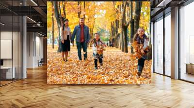 Happy family having holiday in autumn city park. Children and parents posing, smiling, playing and having fun. Bright yellow trees and leaves Wall mural