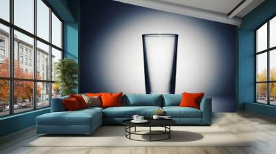 one empty glass for water on a dark blue background Wall mural