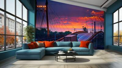 truck with container rides over the bridge, beautiful sunset, freight cars in industrial seaport, the road goes up Wall mural