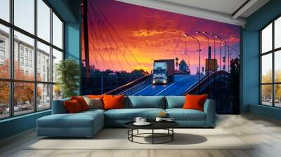 truck with container rides over the bridge, beautiful sunset, freight cars in industrial seaport, the road goes up Wall mural