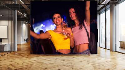 Two happy young girls dancing and drinking beer on the party concert in the night club	 Wall mural