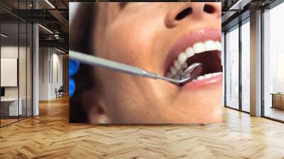 Young woman checking her teeth at the dentist clinic Wall mural