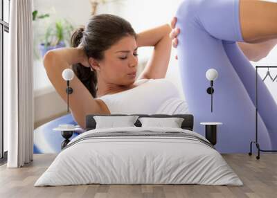 Young woman exercising during physiotherapy with the physiotherapist help in the hospital Wall mural