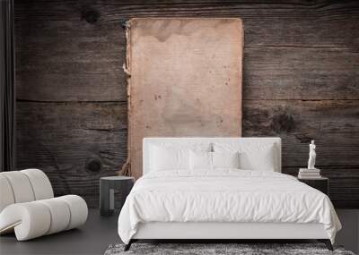 Closed book on vintage wooden background.  Old book on the wooden table. Closed book with empty cover laying on wooden table. Wall mural