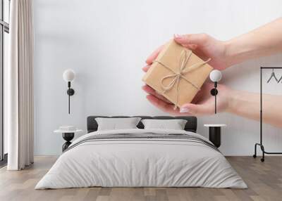 hands of a young girl opening a gift box on a white background Wall mural