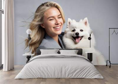 Caucasian white woman playing with a Spitz dog on a white background. Wall mural