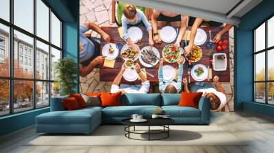 Big family have a dinner with fresh cooked meal on open garden terrace Wall mural