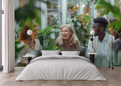 diverse group of friends enjoying cheerful conversation over coffee in cozy cafe surrounded by green Wall mural