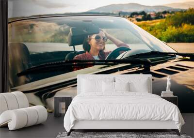 Woman drive cabriolet car: sunset time, mountain province road Wall mural