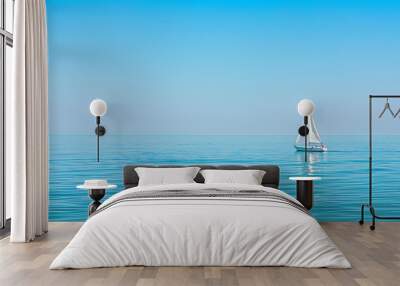 Distant sailboat gracefully gliding on calm waters Wall mural