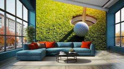 Golf ball is on a green lawn in a beautiful golf course with morning sunshine. Wall mural