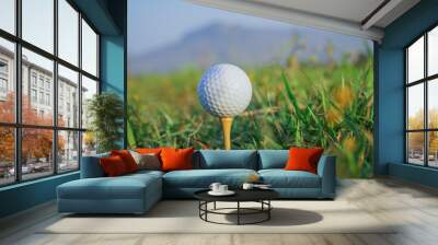 Golf ball on tee ready to play in the evening golf course with sunshine. Wall mural