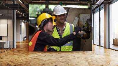 Group of technician man and industrial women worker with hard hat or helmet and vest jacket working electronic machinery and mechanical engineering in Factory of manufacturing place Wall mural