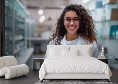 Beautiful young optometrist standing smiling looking at camera while holding digital tablet in standard eyeglasses store Wall mural