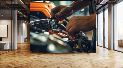 Close-up of a car mechanic using an ammeter to check a car battery in front of the engine bay. Natural light telephoto lens Wall mural