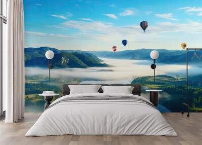 Colorful balloons float above mountains, rivers, and seas of mist. Wall mural