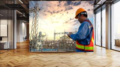 Engineer in uniform and helmet is behind small power plants at construction sites in Asia. Wall mural