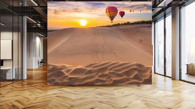 Hot air balloons flying over beautiful sand dunes sunset in the Mui Ne Red Sand Dunes in the North of Mui Ne Village, about 25 km from Phan Thiet City, Vietnam Wall mural