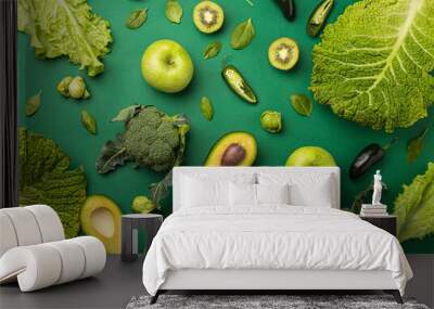 Creative layout healthy organic food concept made of green fruit and vegetables on green background flat lay: avocado, kale, broccoli, Brussels sprouts, kiwi, peppers, apple, cabbage top view
 Wall mural