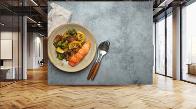 Delicious salmon fillet with grilled Brussels sprouts on plate, rustic stone background top view. Healthy dinner with grilled fish and vegetables, balanced nutrition, space for text Wall mural