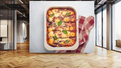 Eggplant parmigiana di melanzane freshly baked and decorated with basil leaves, resting in a baking pan. Classic italian dish Wall mural