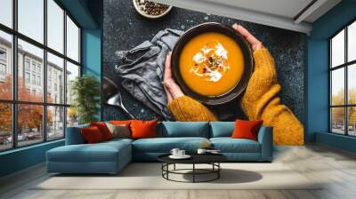 Female hands with bowl of pumpkin soup Wall mural