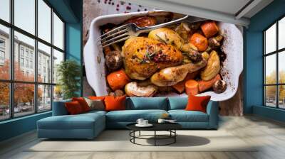 Whole baked juicy chicken with golden crispy skin. Roasted chicken in baking dish with apples, carrot, mushrooms, rosemary, garlic, pepper on rustic iron oven-tray. Overhead. Dinner. Cooked poultry Wall mural