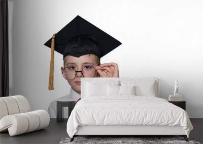 Boy in a square academic cap and white shirt correcting glasses. School concept. Isolate Wall mural