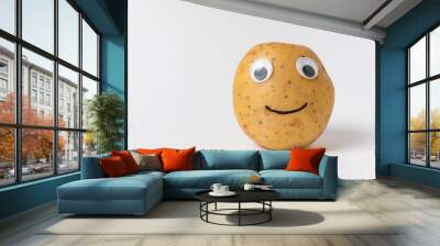 Funny raw potatoes with Googly eyes and smile on white background. Food with funny face Wall mural