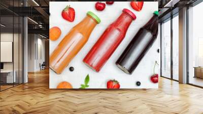 Three bottles with juice, fruit on a white wooden background. Food concept Wall mural