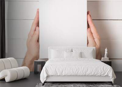 White rectangular box in male hands. Top view. White table on the background Wall mural