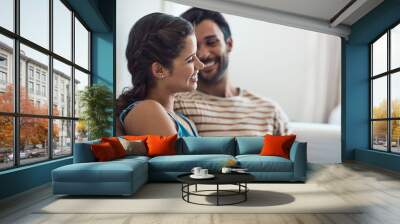 Home, couple and happy with bonding on sofa for love, trust and care with funny conversation. People, relationship and smile with discussion or joke as lovers for laughing and support in living room Wall mural