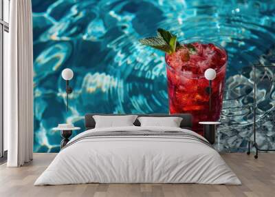 A vibrant red drink sits on a table next to a clear blue pool under the sun Wall mural