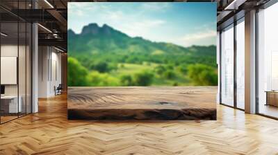 A wooden table with a mountain in the background, the tables surface featuring visible grain patterns and natural imperfections, set against a blurred mountain landscape Wall mural