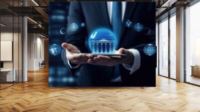 Business man holding in hands tablet pc with glowing bank icon with International business network connection and futuristic interface on dark blue background. Wall mural